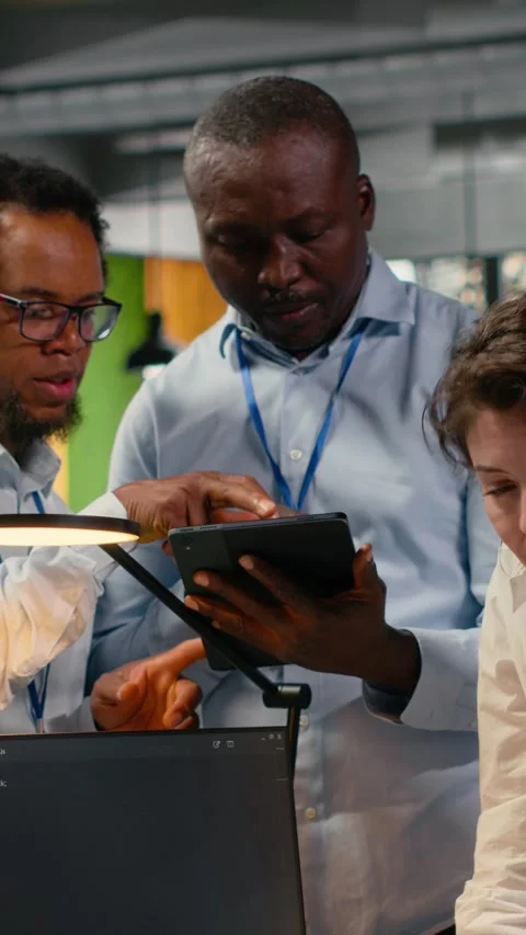 Vertical video Multiethnic technicians use devices in AI startup to train Stock Footage 323143016