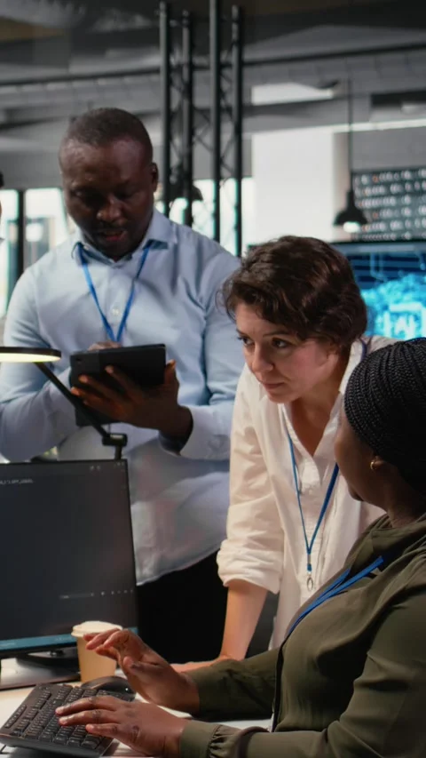 Vertical video Multiethnic technicians use devices in AI startup to train Stock Footage 323404328