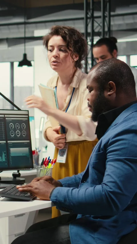 Vertical Video Multiethnic work team consulting each other in completing monthly Stock Footage 313695005