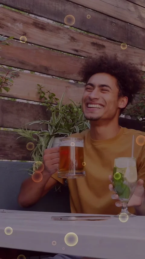 Vertical video: Mustard guy dining, laughing after woman joke, raising beer mug, Stock Footage 333913092