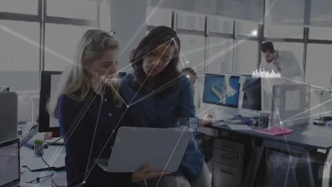 Vertical video: Network overlay appearing, two women holding laptop, pointing Stock Footage 331045554