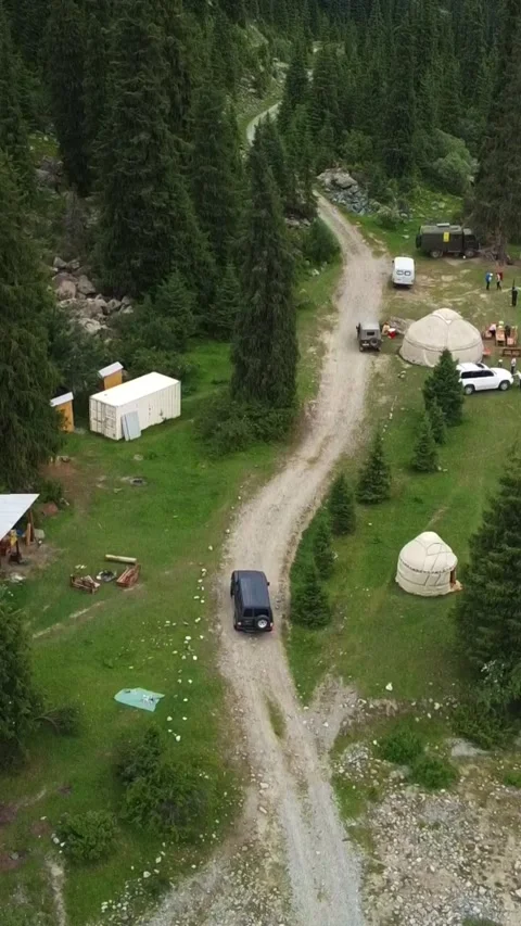 Vertical video: Nomad Yurt Camp and SUV by Rushing Mountain River Aerial Stock Footage 332205256