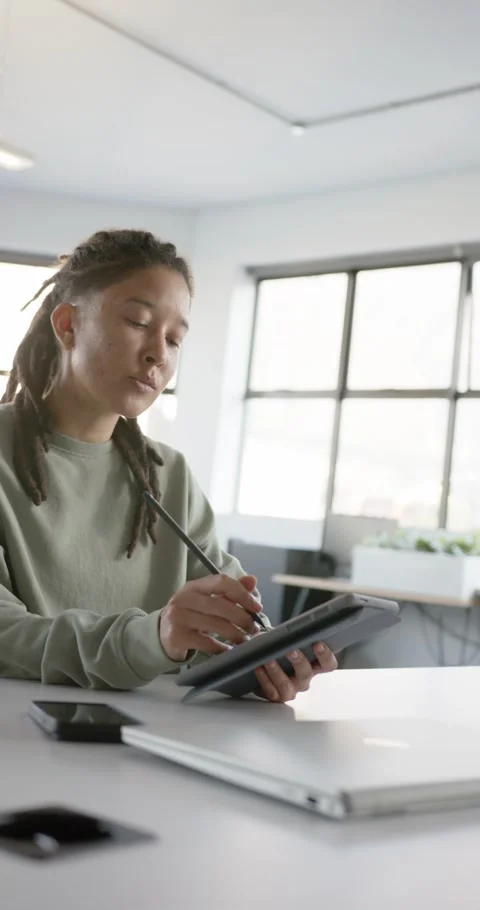 Vertical video: Non-binary artist sketching on tablet with stylus at studio Stock Footage 344695579