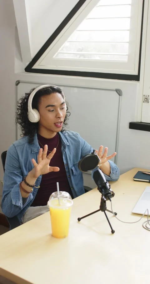 Vertical video: Non-binary creator after cue gesturing toward mic, explaining Stock Footage 346718616