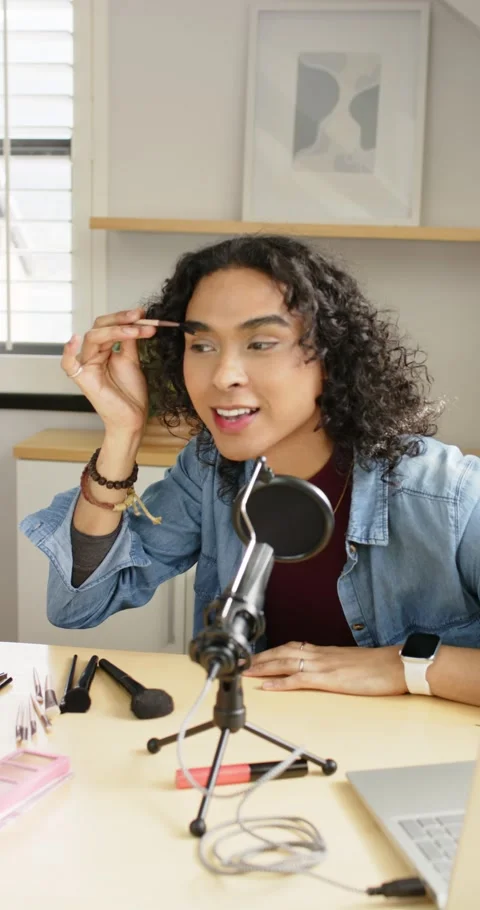 Vertical video: Non-binary vlogger reaching for eyebrow brush, filling brows at Stock Footage 345128986