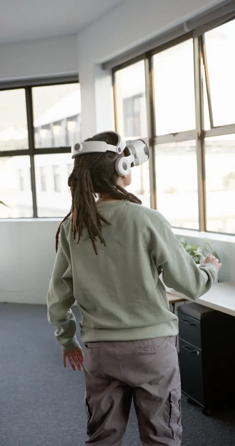 Vertical video: Non-binary with white VR headset after VR cue exploring planter Stock Footage 344695612