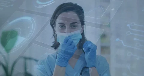 Vertical video: Nurse after adjusting gloves, pulling mask down, revealing smile Stock Footage 331227472