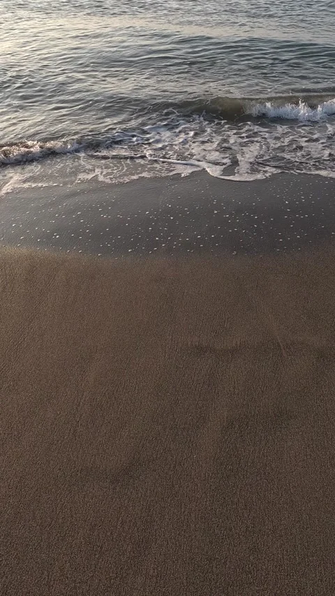 Vertical video of ocean waves crashing on a sandy beach Video stock 342494642