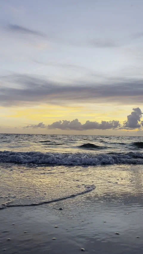 Vertical video of ocean waves on Florida beach at sunset Stock Footage 345965802