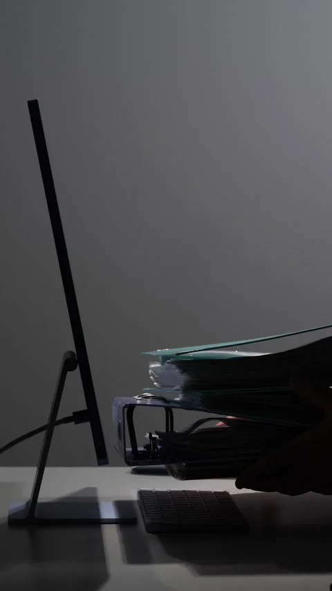 Vertical video office desk with a computer monitor, keyboard, and stacked file Stock Footage 342671985