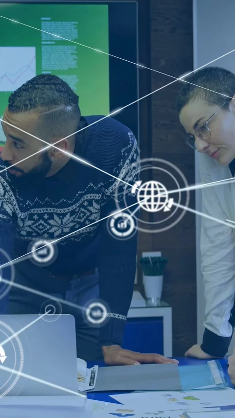 Vertical video: Office duo leaning over table, HUD expanding, pointing at laptop Stock Footage 332869153