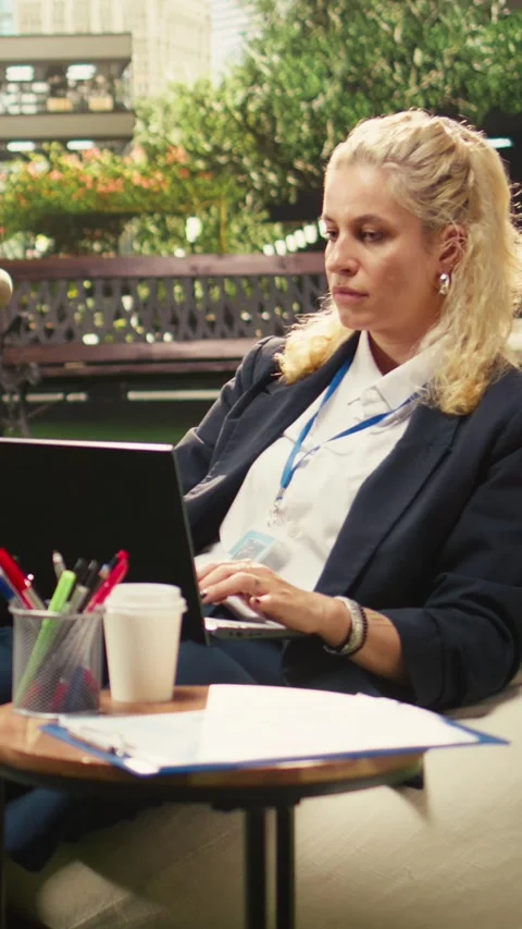Vertical Video Office employee taking notes on laptop during outdoor planning Stock Footage 339070500