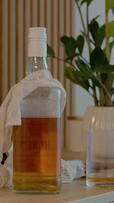 Vertical video Office table with liquor, glass, and discarded women's clothing Stock Footage 327577230