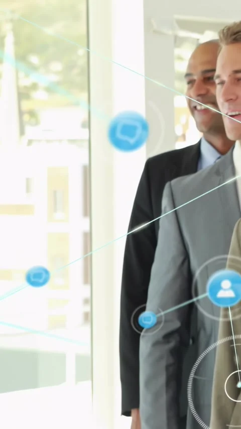 Vertical video: Office team posing at glass, camera panning, blue icons moving Stock Footage 334604365
