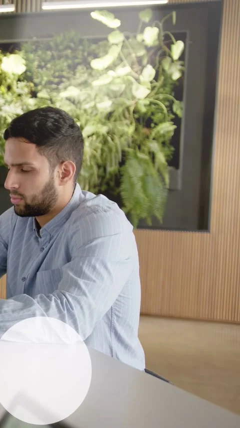 Vertical video: Office worker checking laptop, leaning in as bokeh passing over Stock Footage 333542210