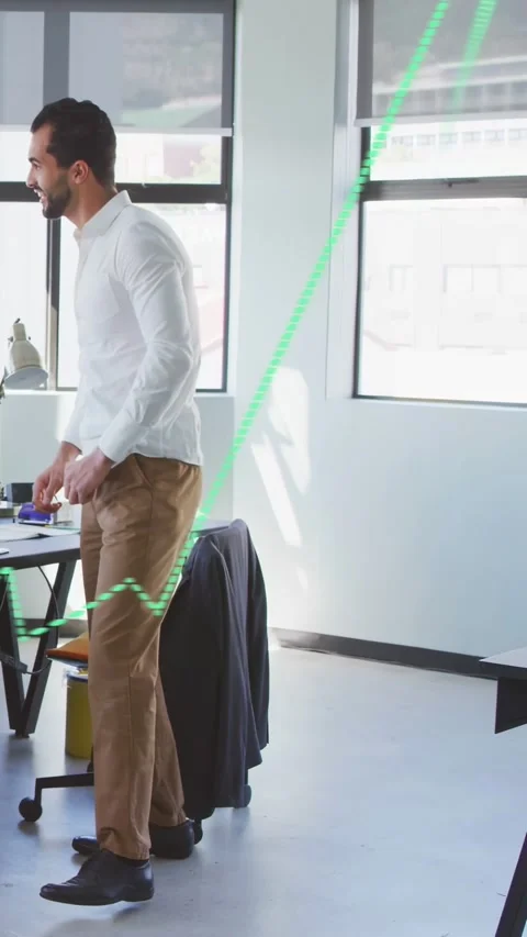 Vertical video: Office worker leaning at desk tidying items, sparking green Stock Footage 333260145