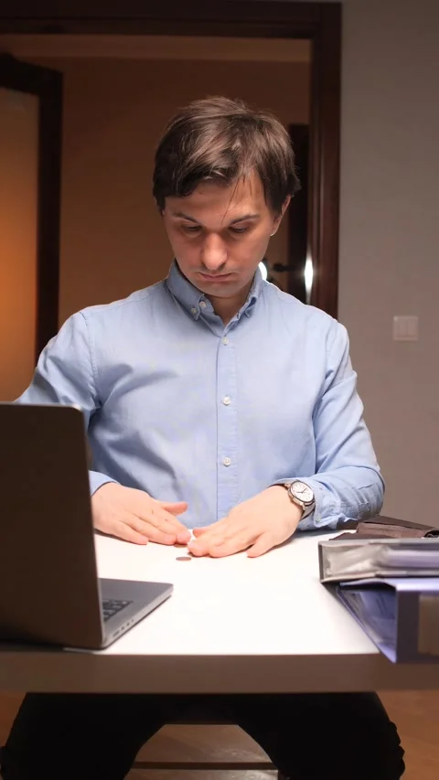 Vertical video Office worker shaking empty wallet at desk with laptop Stock Footage 307418962