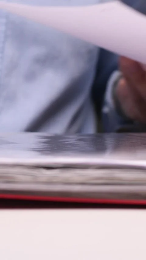 Vertical video Office worker stapling documents to a folder using a blue stapler Stock Footage 308400778