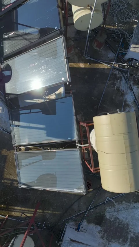 Vertical Video: Old rooftop featuring solar panels and water barrels under a Stock-Footage 342702919