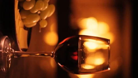 Vertical video of one red wine wineglasses over fireplace background. Stock Footage 98927374