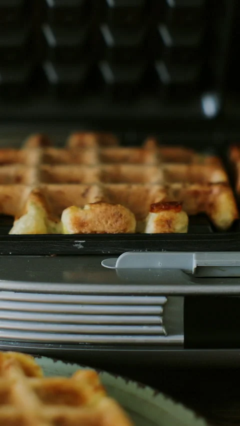 Vertical video. Opened waffle iron with freshly baked Belgian waffles. Baking 스톡 동영상 347154340