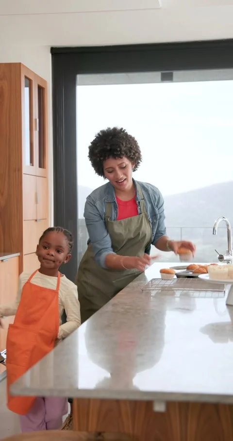 Vertical video: Opening oven mother guiding African-American girl moving buns Stock Footage 345040286