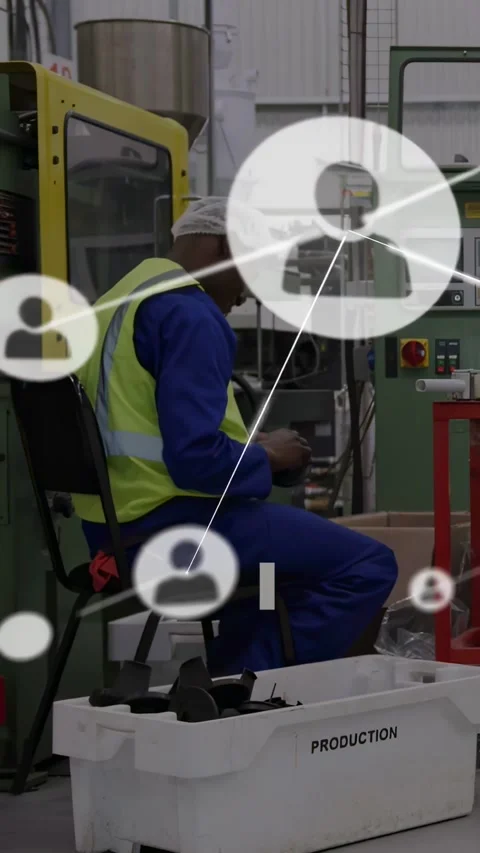 Vertical video: Operator reaching into PRODUCTION bin feeding machine for Stock Footage 331215842