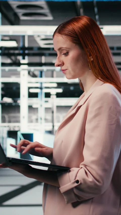 Vertical video Optimizing electronics, laptop and woman in server farm Video stock 330375570