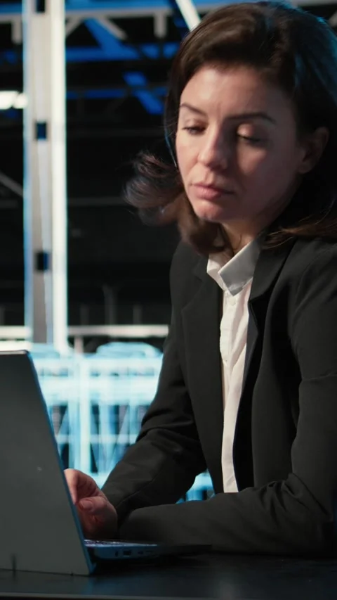 Vertical video Optimizing server, laptop and software developer in data center Stock Footage 329322254