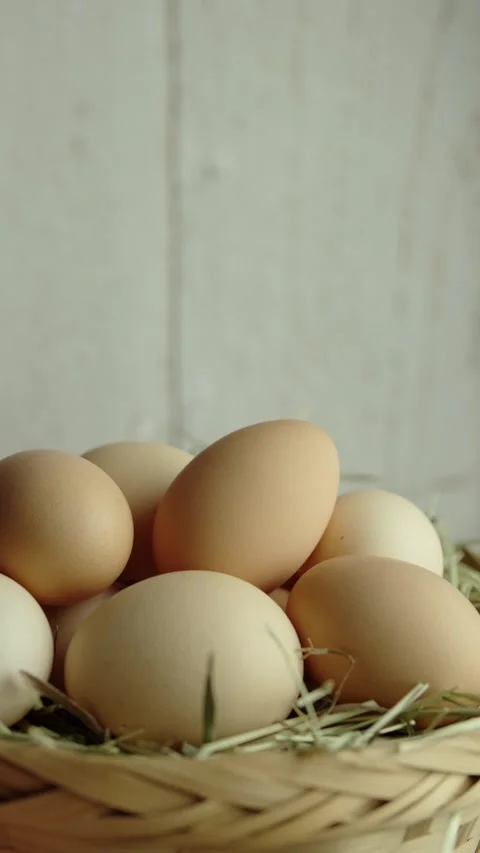 Vertical video Organic eggs and hay in a wicker basket  Travel shot left Stock Footage 280628102