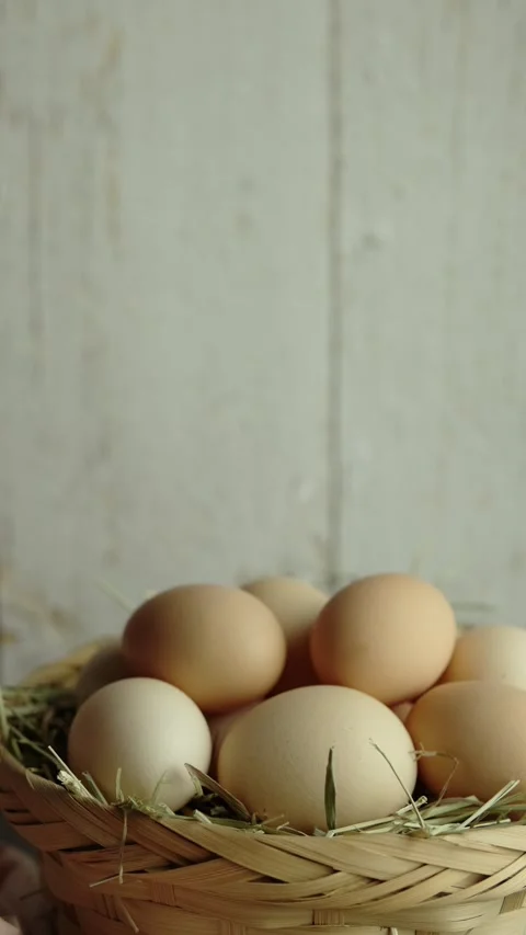 Vertical video Organic eggs and hay in a wicker basket  Dolly back Stock Footage 280628131