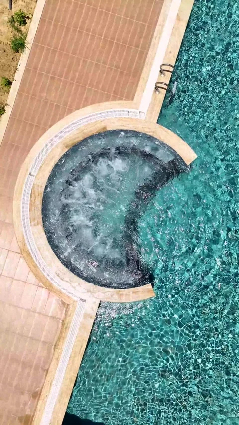 Vertical Video: Outdoor Pool with Transparent Water and Jacuzzi Bubbles in a Stock Footage 297712529