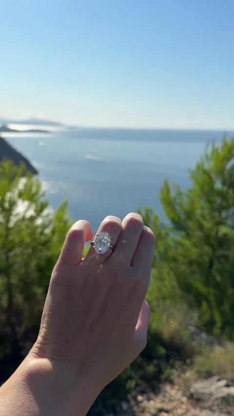 Vertical video oval diamond ring hand above sea and pine trees view Stock Footage 319456080
