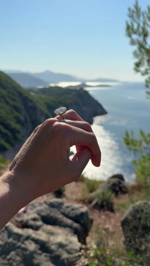 Vertical video oval diamond ring hand against scenic mountain view Stock Footage 319456081