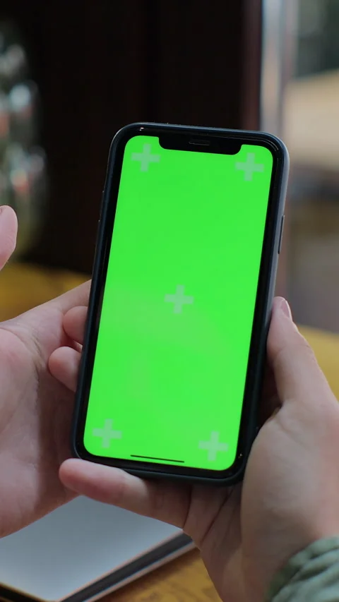 Vertical video. Over the shoulder view of man using green screen smartphone Video stock 345239777