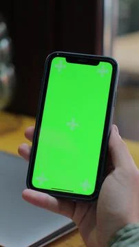 Vertical video. Over the shoulder view of man using green screen smartphone.. Foto stock