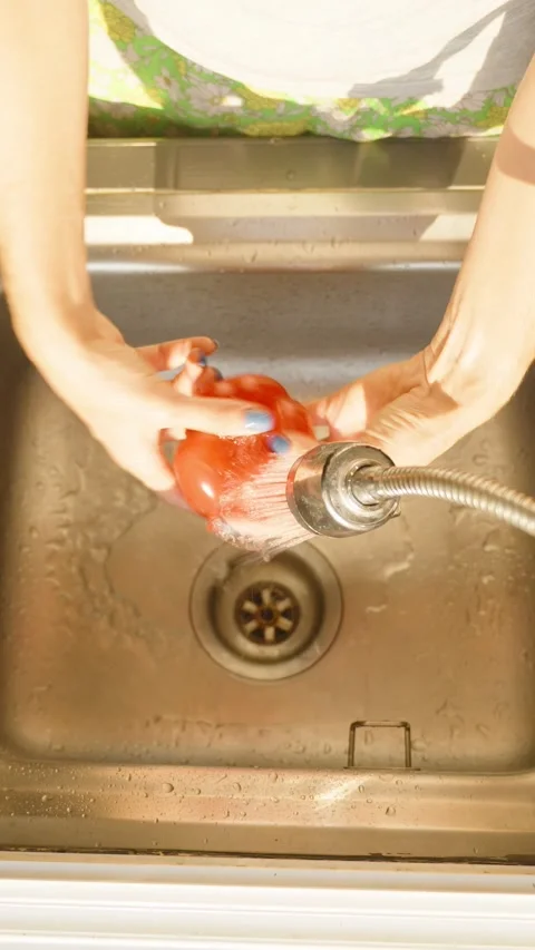 Vertical video. Overhead View of Person Washing Red Bell Pepper in Kitchen Sink Stock Footage 315239681