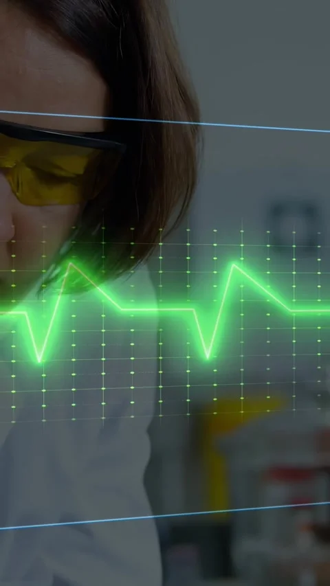 Vertical video: Overlay causing scientist in yellow specs, coat checking data at Stock Footage 330542852