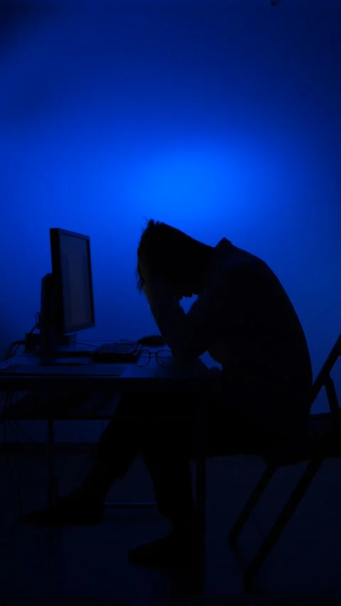 Vertical video Overworked man experiencing stress and burnout working late night Stock Footage 318982747