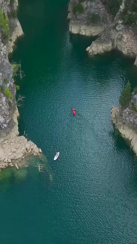 Vertical Video: Paddleboard Trip Through a Green Canyon with People Floating Stock Footage 297773128