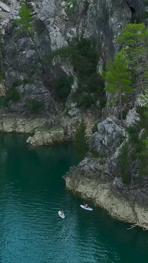 Vertical Video: Paddleboarding Through a Green Canyon with People Swimming Video stock 297780258