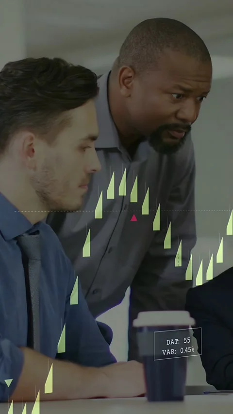 Vertical video: Pair reviewing live market feed causing candlestick charts on Stock Footage 334024847