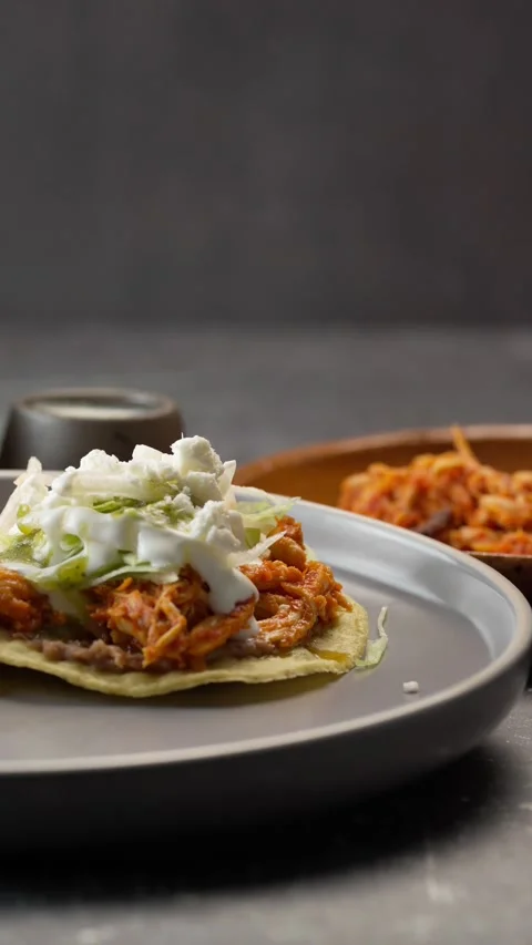 Vertical video of a pair of tinga tostadas, panned to the left in slow motion Stock Footage 282549260