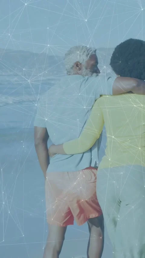 Vertical video: Pair walking linked caring camera tracking shore net overlay Stock Footage 334604732