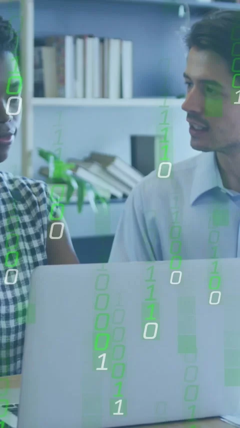 Vertical video: Pair working, green binary overlay appearing over laptop, Stock Footage 332278619