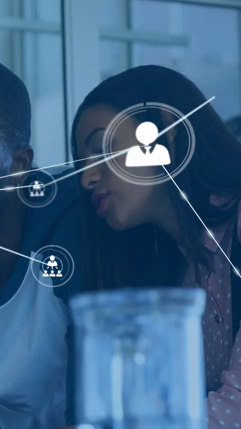 Vertical video: Pair working over device, woman pointing, tech nodes UI growing Stock Footage 333895689