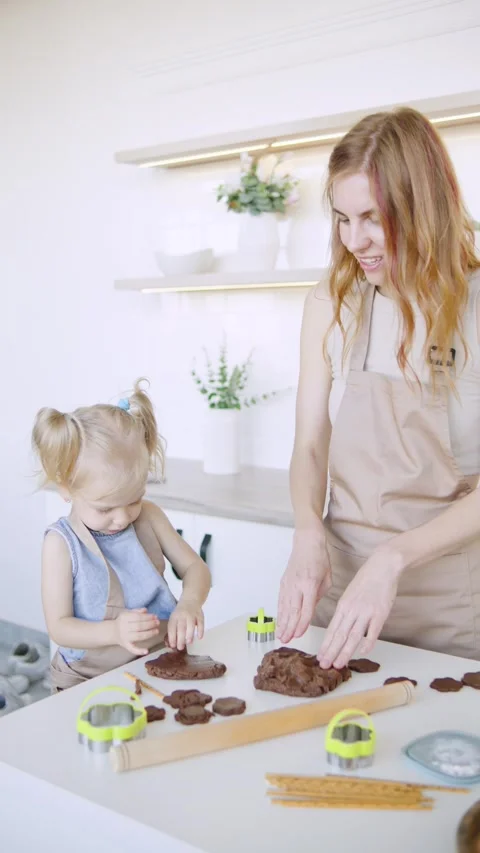 Vertical video Parent and child making cookies together in a bright kitchen Stock Footage 308491253