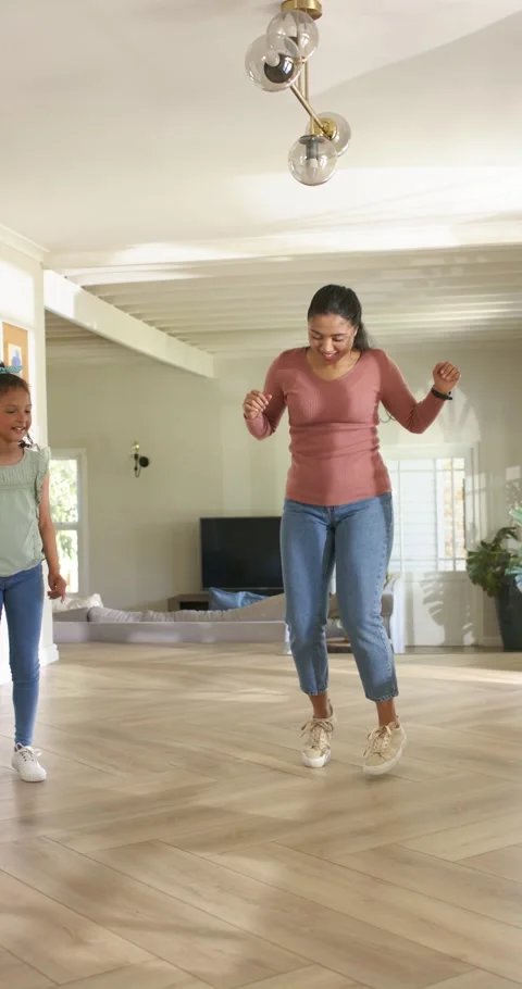 Vertical video: Parent and child mom starting steps and hops amusing child in Stock Footage 345217586