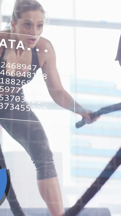 Vertical video: Partner tapping timer, two women waving ropes in gym while Stock Footage 333479985