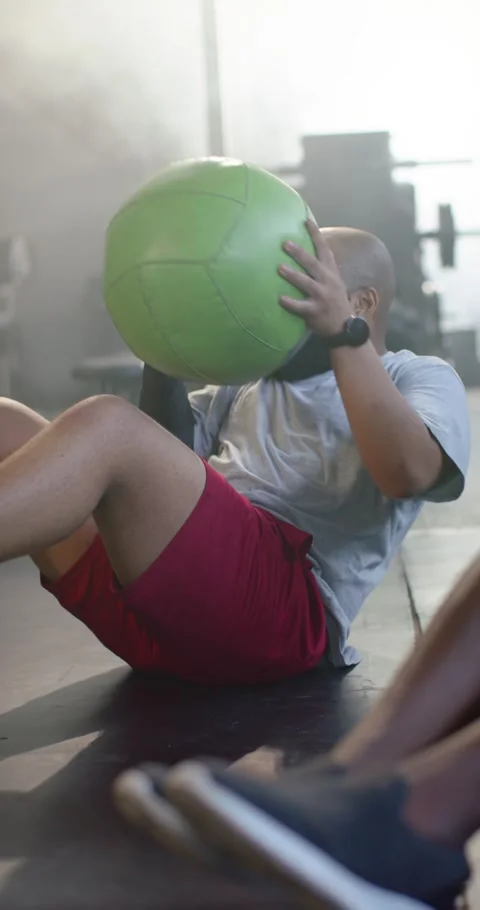 Vertical video: Partners passing ball as African American man doing Russian Stock Footage 345492693